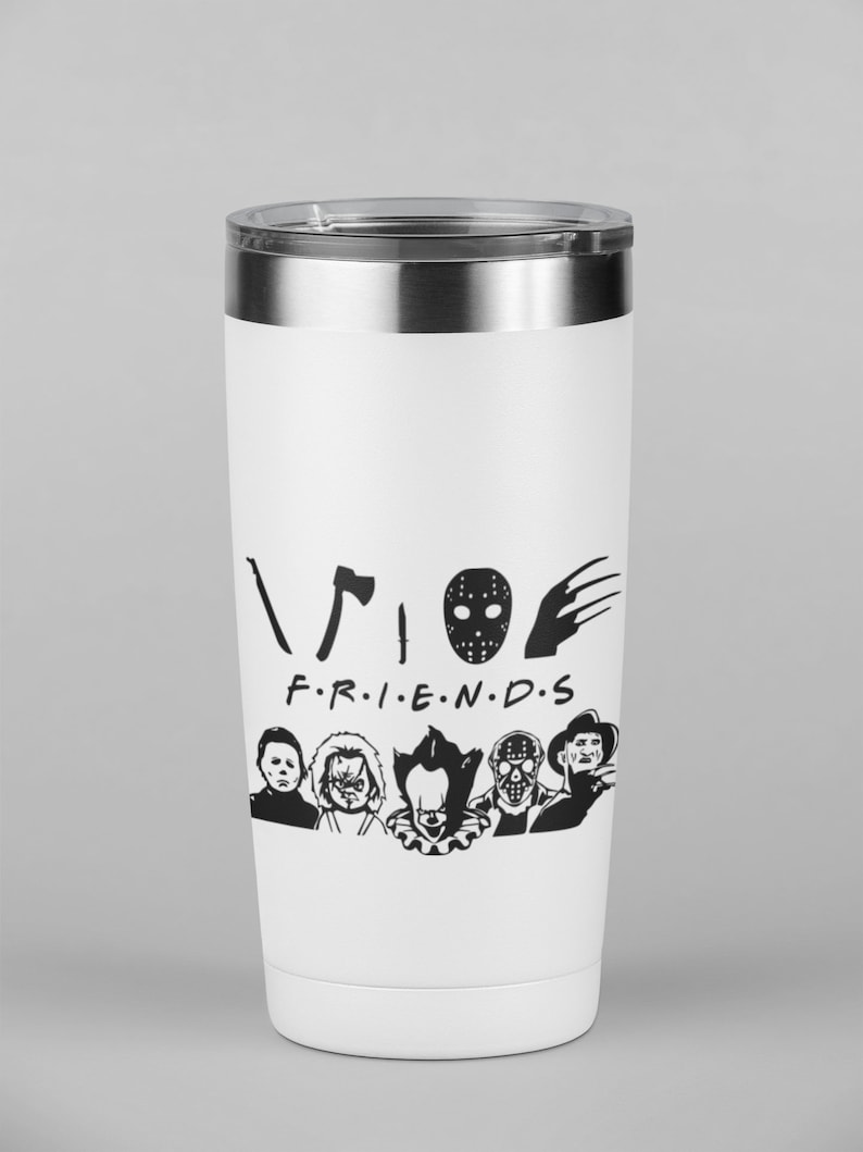 以下が含まれることがあります： 黒いホラー映画のキャラクターのグラフィックと「FRIENDS」というテキストが書かれた白いステンレス製のタンブラー。テキストの上に黒い斧、ホッケーマスク、爪痕があります。