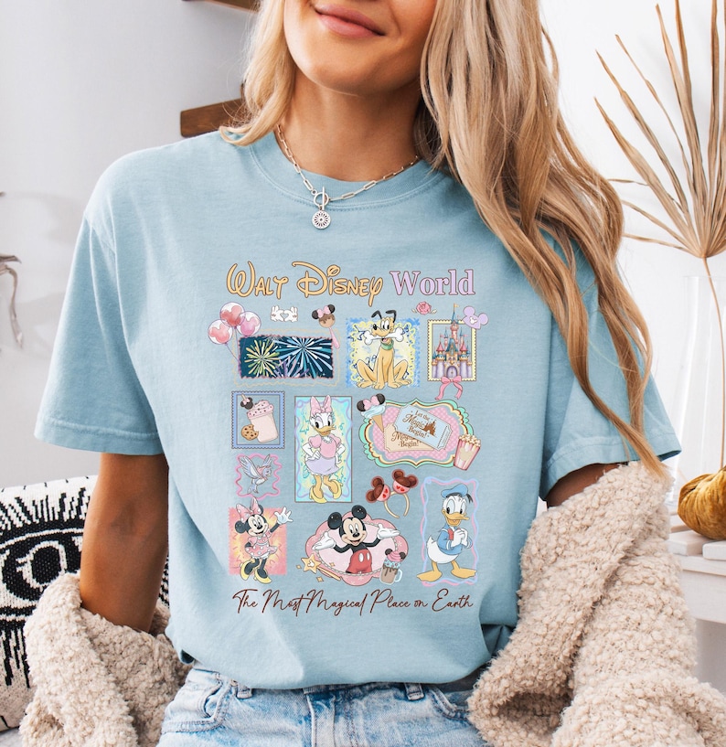 A woman wearing a light blue t-shirt with a Disney World-themed graphic printed on it.