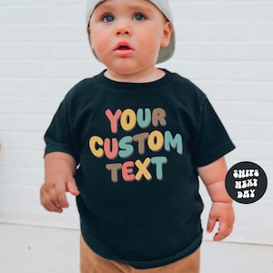 a baby wearing a t - shirt that says your custom text