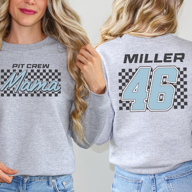 Two women wearing grey sweatshirts with text and numbers on them.