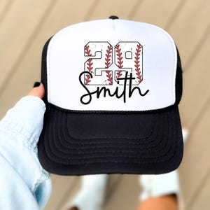 a person holding up a baseball hat with the word south on it