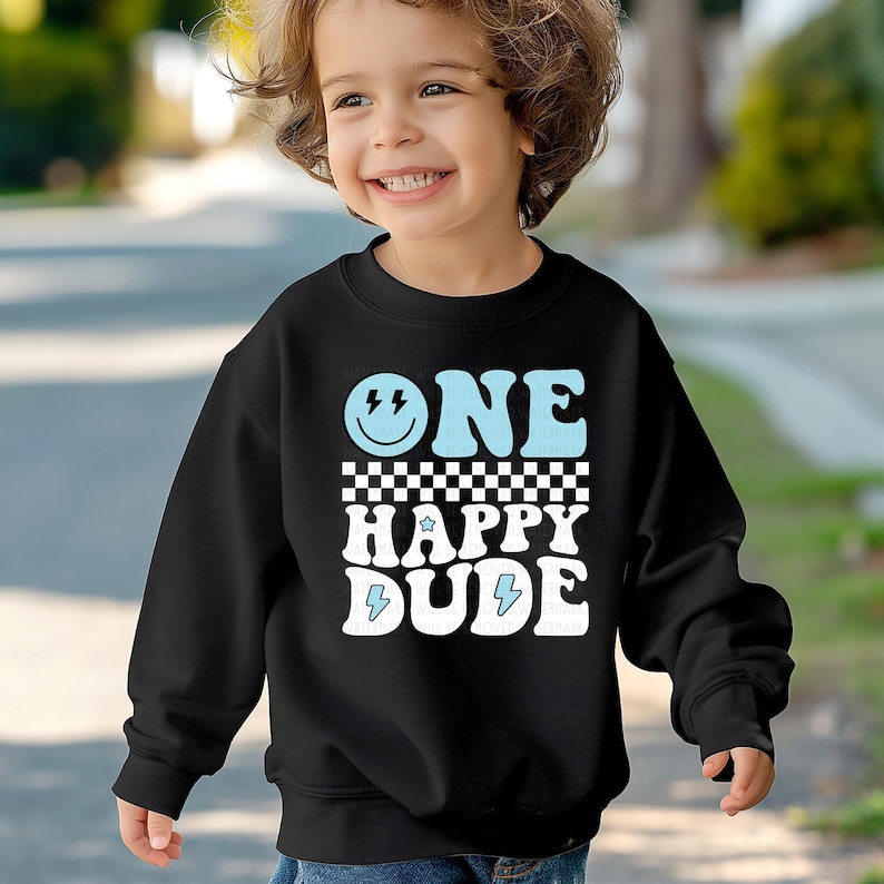 a young boy wearing a black sweatshirt that says one happy dude