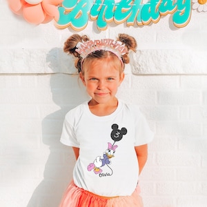 a little girl standing in front of a birthday sign