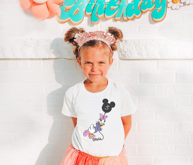 a little girl standing in front of a birthday sign