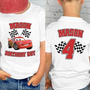 A white t-shirt with a red and black design featuring a red car and checkered flags, along with the text "MASON BIRTHDAY BOY" and the number "4".