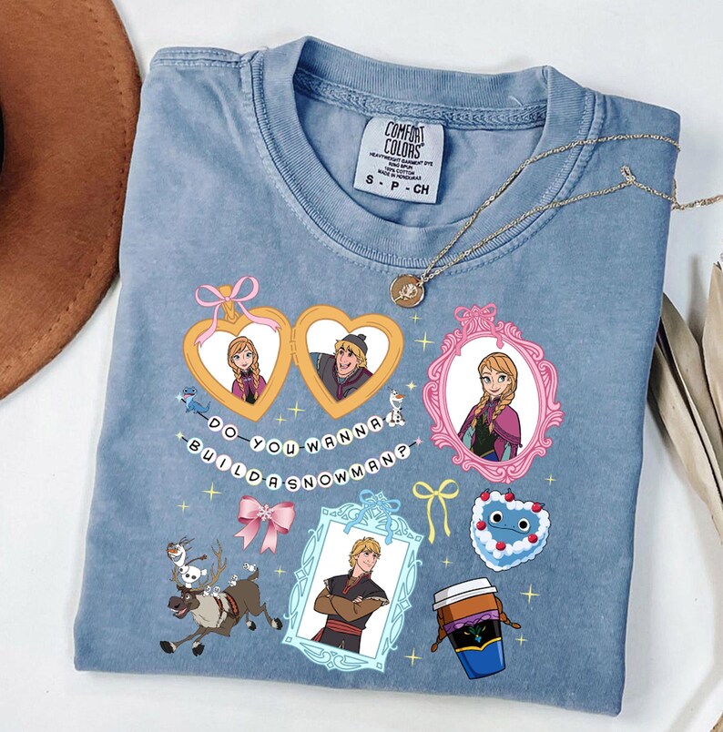 A blue t-shirt with various cartoon-style illustrations and text, including characters, objects, and phrases.