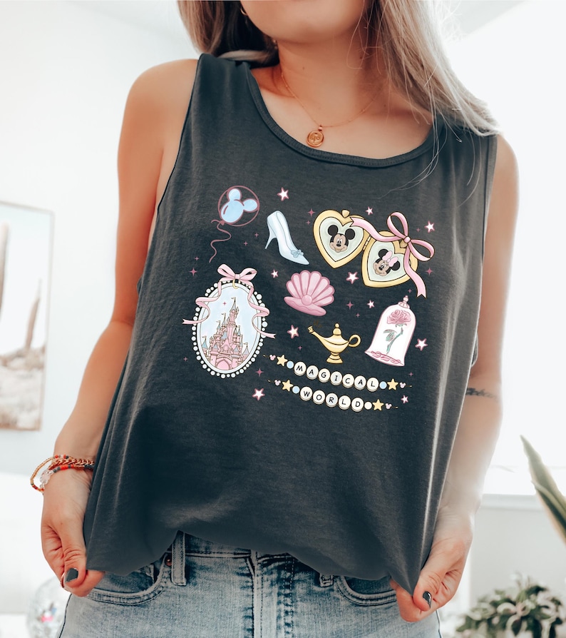 A woman wearing a black tank top with a graphic design featuring various Disney-themed elements such as Mickey Mouse, Minnie Mouse, a castle, and a magic lamp.