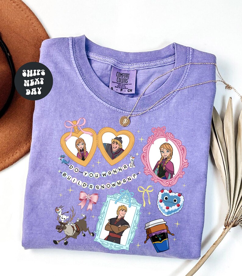 a purple t-shirt with various cartoon-style illustrations and text, including characters and objects such as a cup, a hat, and a snowman.