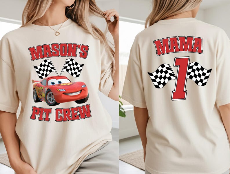 A woman wearing a white t-shirt with a red and black design featuring a red car and checkered flags, along with the text "Mason's Pit Crew" and the number "1".
