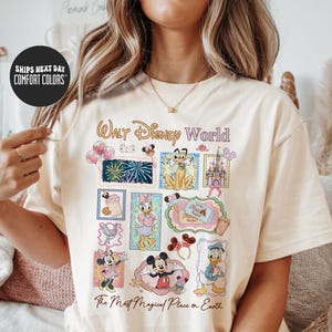 A woman wearing a white t-shirt with a Disney World-themed design, including various Disney characters and landmarks.