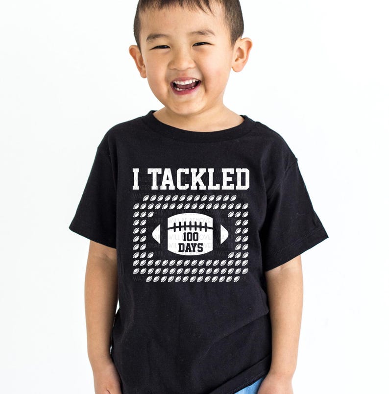 A young boy wearing a black t-shirt with a graphic design and text printed on it.