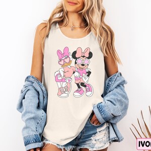 a woman wearing a mickey and minnie mouse shirt