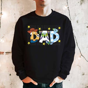 a man wearing a black sweatshirt with the word dad printed on it