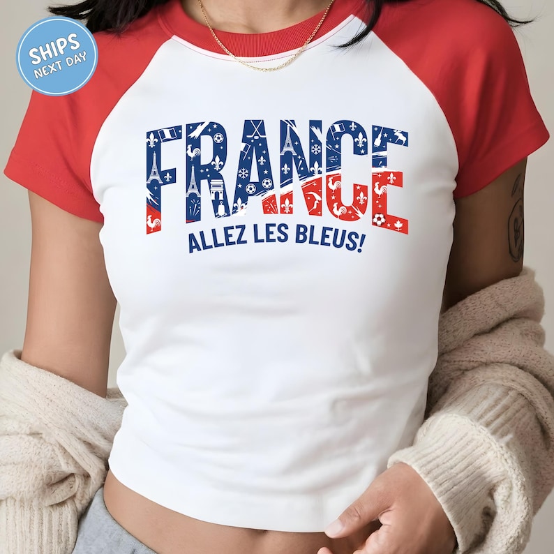 A person wearing a white and red t-shirt with the text "FRANCE ALLEZ LES BLEUZ!" printed on it.