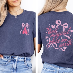 a woman wearing a gray t-shirt with a pink castle graphic and text on the back.