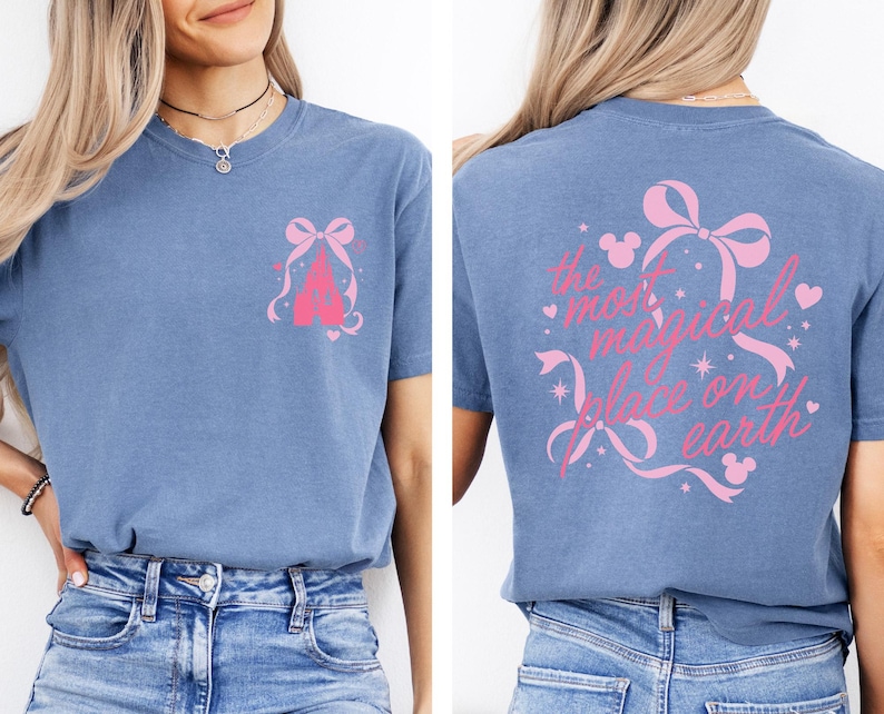 A woman wearing a blue t-shirt with a Disney castle graphic and text on the back.