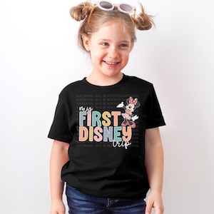 a little girl wearing a mickey mouse shirt