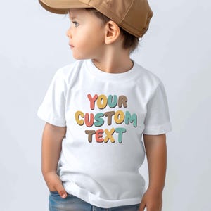 a little boy wearing a white shirt and a brown hat