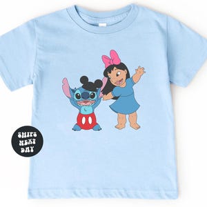 A light blue t-shirt with a cartoon image of two characters, Stitch and Lilo, standing next to each other.