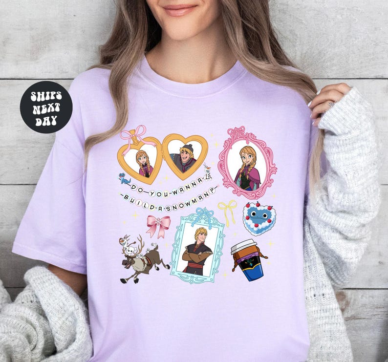 A woman wearing a pink t-shirt with various cartoon characters and text printed on it.