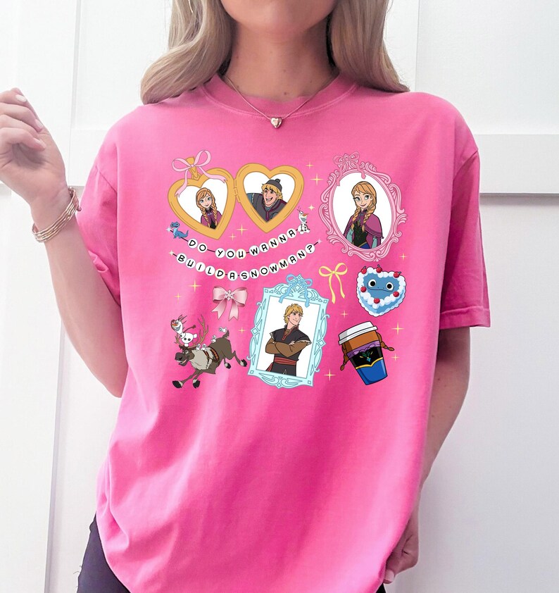 A pink t-shirt with various cartoon-style illustrations and text, including characters, objects, and phrases.