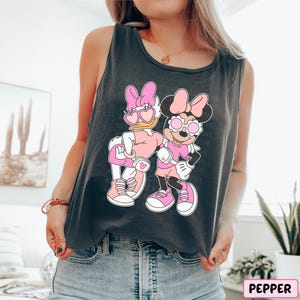 a woman wearing a tank top with a cartoon character on it