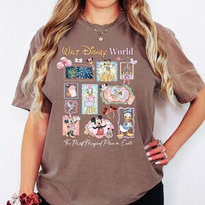 A woman wearing a t-shirt with a Disney World-themed design, including various Disney characters and landmarks.