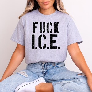 a woman sitting on a chair wearing a t - shirt that says fuck ice