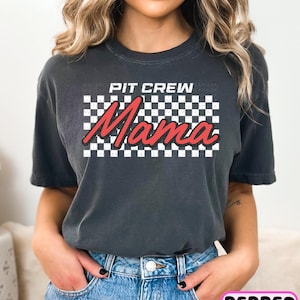 a woman wearing a black t - shirt with a checkered design