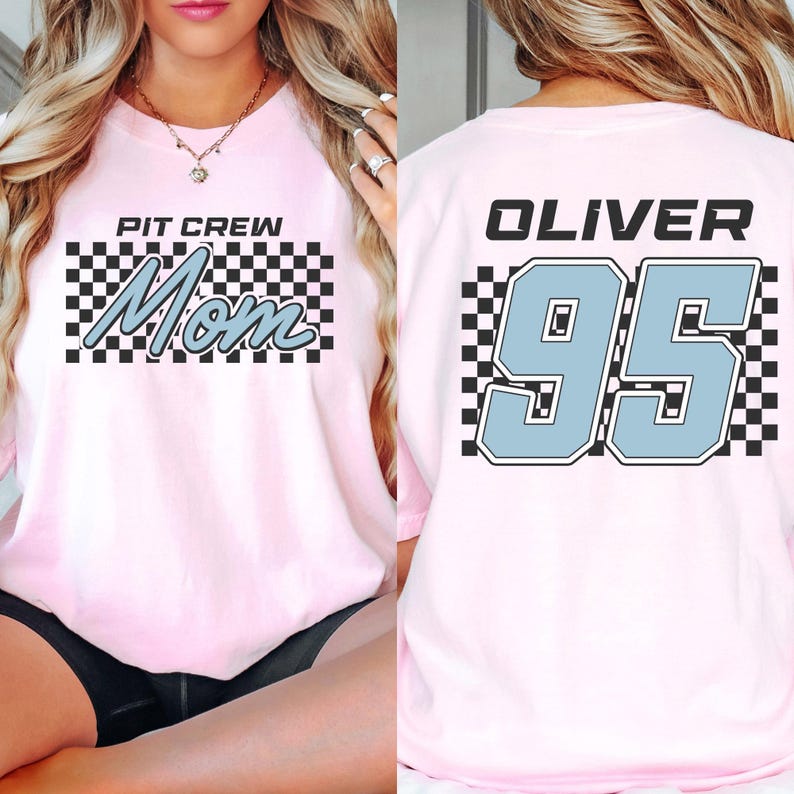 A woman wearing a pink t-shirt with a checkered pattern and the text "PIT CREW Mom" printed on it.