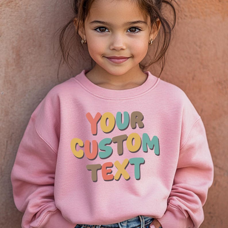 a little girl wearing a pink sweatshirt with a custom text on it