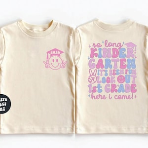 two white t-shirts with colorful text and graphics on them.
