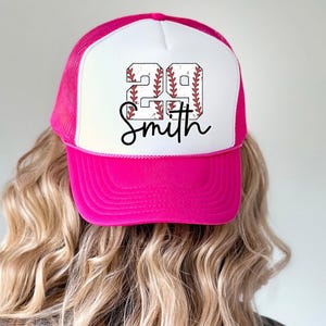 a woman wearing a pink and white baseball hat