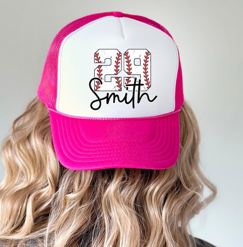 a woman wearing a pink and white baseball hat