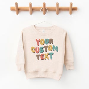 a sweater hanging on a wooden hanger