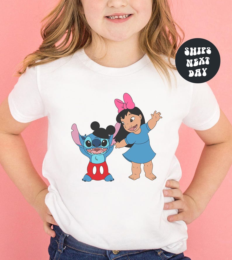 A young girl wearing a white t-shirt with a graphic of Stitch and Lilo from the Disney movie Lilo & Stitch.