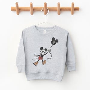 a mickey mouse sweatshirt hanging on a clothes line