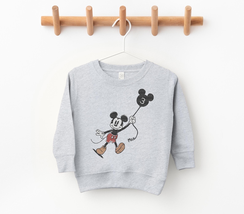 a mickey mouse sweatshirt hanging on a clothes line