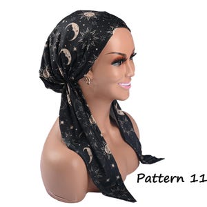 May include: A black head wrap featuring a celestial print of cream-coloured suns, moons, and stars. The fabric is tied at the back with two long, trailing ends. The text "Pattern 11" is printed in black in the lower right corner of the image.