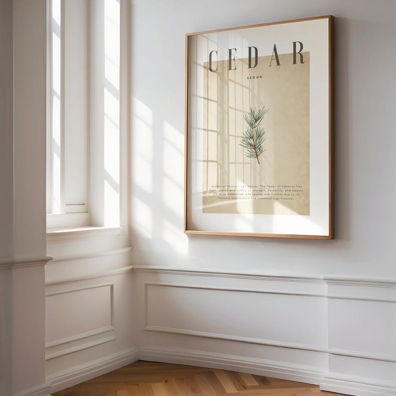 May include: A framed print with the word "CEDAR" in large, dark letters. Below, a botanical illustration of a cedar branch is displayed. The print is in a light-colored frame, hanging on a white wall.