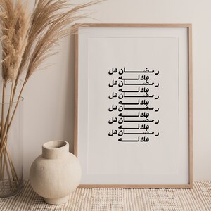 May include: A framed print with black Arabic calligraphy on a white background. The text reads "Ramadan Hal, Hilalah, Ramadan Hal, Ramalan Hal, Hilalah, Ramadan Hal, Ramalan Hal, Hilalah, Ramadan Hal, Ramalan Hal, Hilalah, Ramadan Hal".