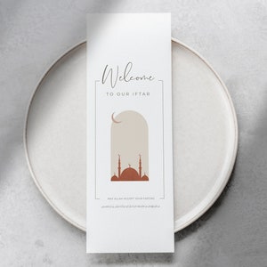 May include: A white card with the text "Welcome to our Iftar" and a graphic of a mosque with a crescent moon. The text "May Allah accept your fasting" is also included.