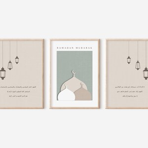 May include: Three printable art prints with a beige background and brown accents. The center print features a mosque with a green background and the text "RAMADAN MUBARAK". The left and right prints feature hanging lanterns and Arabic text.