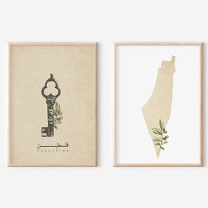 May include: Two beige framed prints with a vintage key and olive branch on the left and an outline of Palestine with an olive branch on the right. The text "Palestine" is written in English and Arabic below the key.