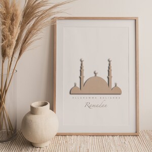 May include: A framed print with a beige mosque silhouette and the text "Allahuumma Balighna Ramadan" in a light brown font.