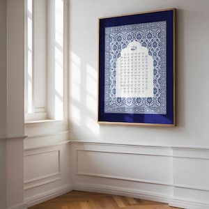 May include: A framed wall art piece featuring a blue and white patterned design with Arabic calligraphy. The artwork is set against a dark blue background within a wooden frame, creating a striking contrast. The piece is displayed on a white wall in a well-lit room.
