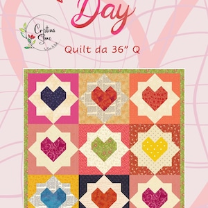 Può includere: Una trapunta di San Valentino con nove blocchi a forma di cuore in vari colori, ciascuno circondato da un disegno a stella a otto punte. La trapunta misura 91 cm di larghezza e include il testo "Valentine's Day".