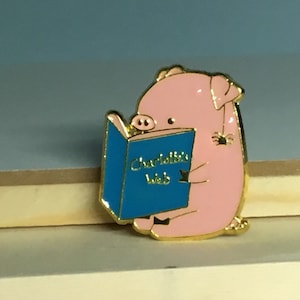 Pig Reading Charlotte’s Web with a Little Spider Enamel Pin