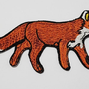 May include: An embroidered patch of a red fox with white accents. The fox is walking with its tail curled behind it.