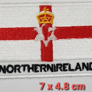 Puede incluir: Parche blanco bordado con la bandera de Irlanda del Norte. La bandera presenta una cruz roja sobre un fondo blanco con una mano roja y una corona dorada en el centro. Las palabras "NORTHERN IRELAND" están impresas en negro debajo de la bandera. El parche mide 7 cm por 4,8 cm.